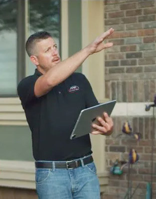 An Mid Kansas Exteriors estimator points to an unseen roof.