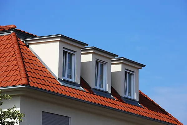 Clay tile roofing on a home. There are three dormer windows.